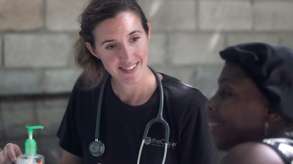 A medical practitioner wearing a stethoscope talking to a patient