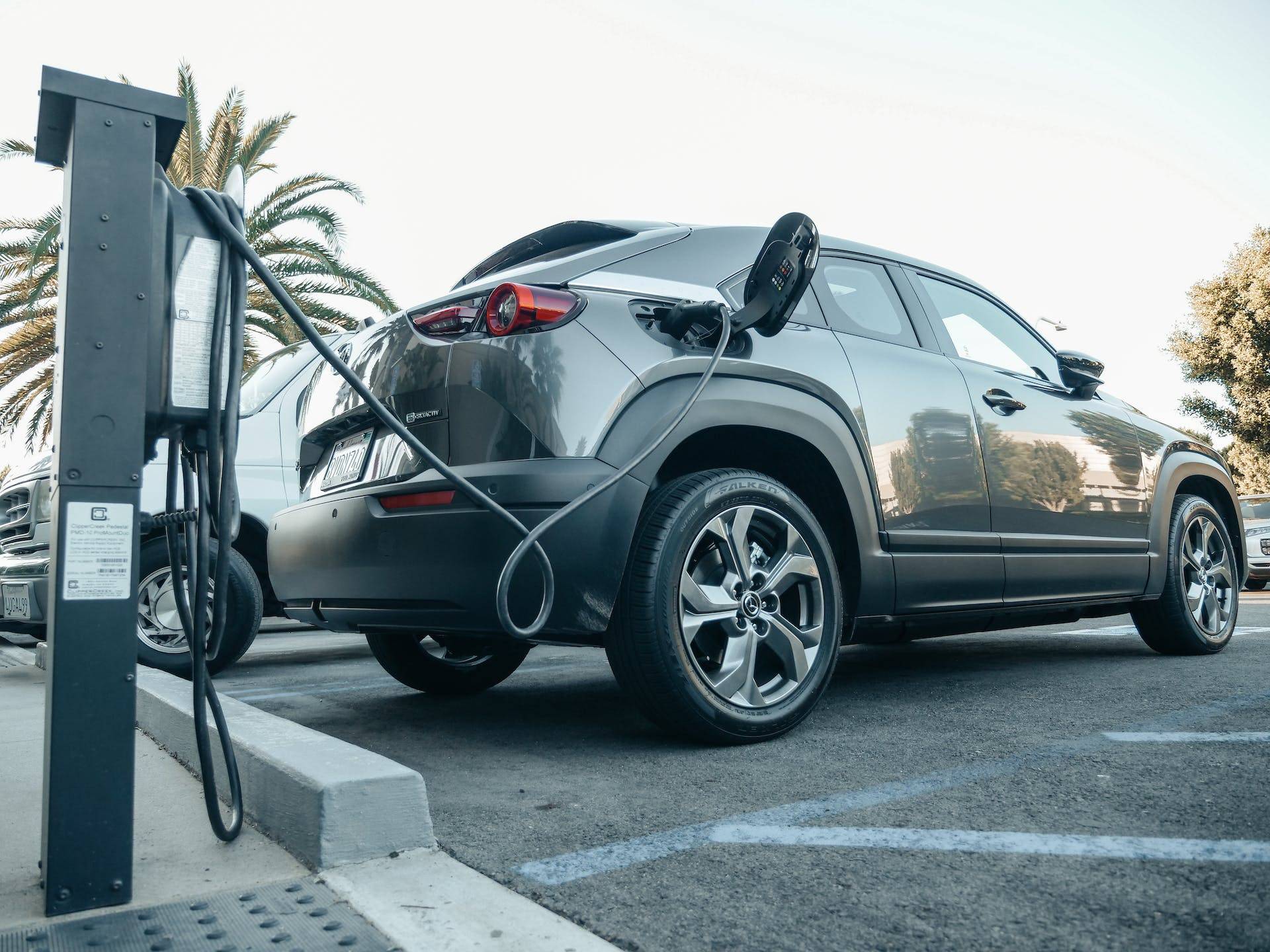 Electric car charging at a public station, made possible by the hard work of a Technical Writer developing Standard Operating Procedures