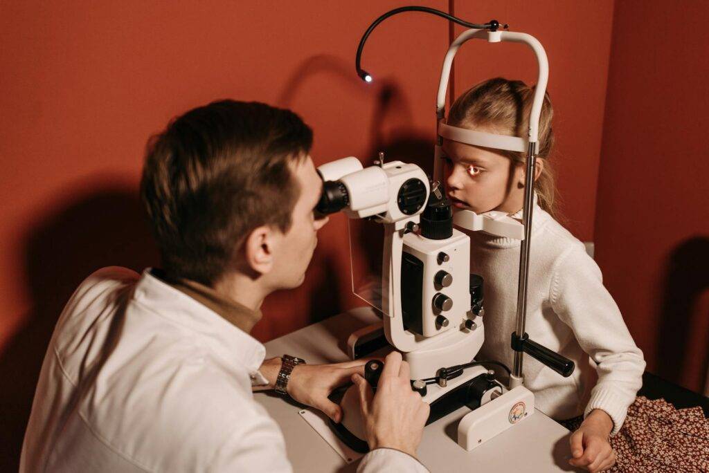 a Doctor Looking at a Young Patient's Eyes Through a Machine, Representing the Importance of SOP Writing Services