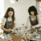 Two women preparing pastries at a restaurant table