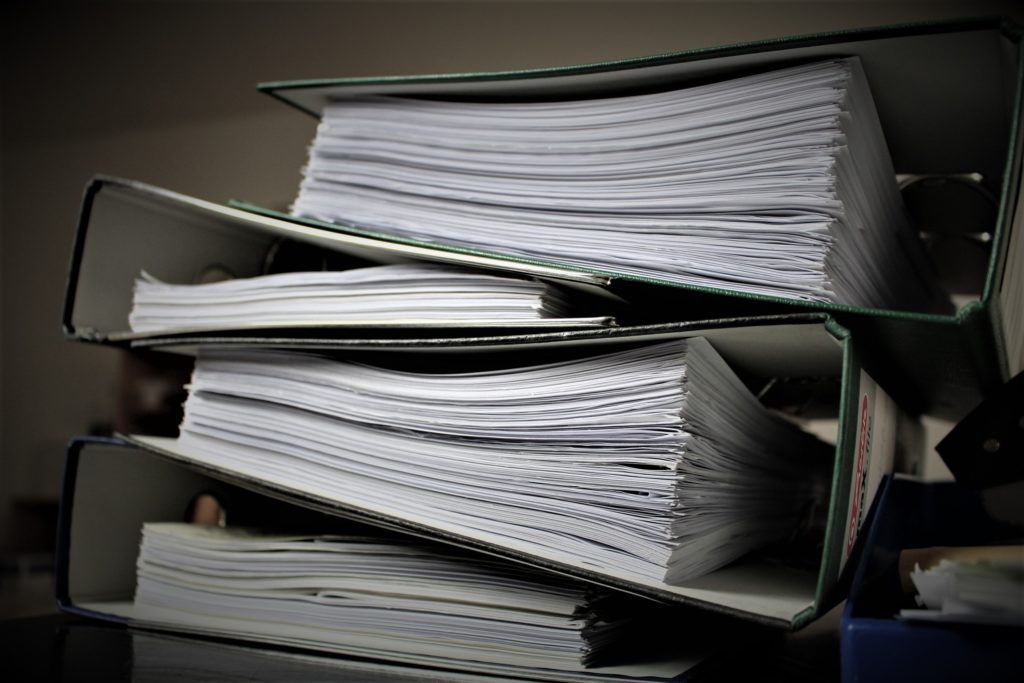 A thick stack of binders full of paper.