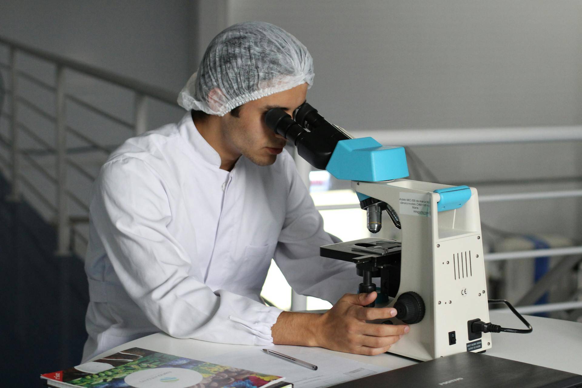 a Medical Researcher looking through a Microscope, representing the importance of Comprehensive User Guides made by Medical Technical Writers