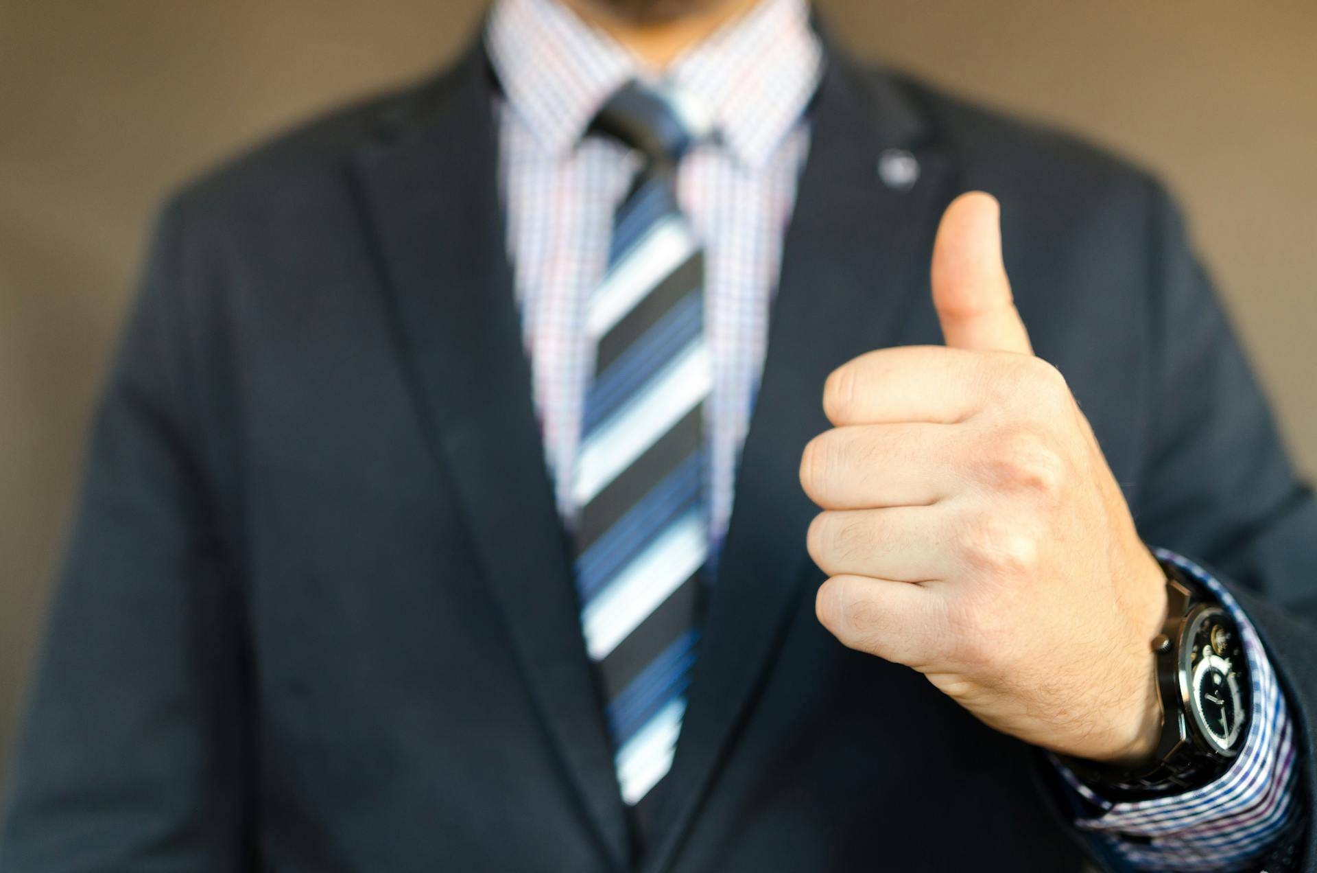 a Person in a Suit Giving a Thumbs Up, representing the Positive Impact of Comprehensive User Guides made by Medical Technical Writers
