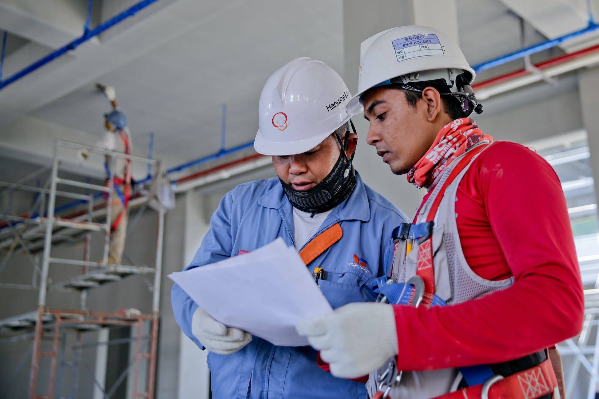 Two Construction Workers Reading Plans, Representing the Importance of Technical Writing for Operations Manual Development