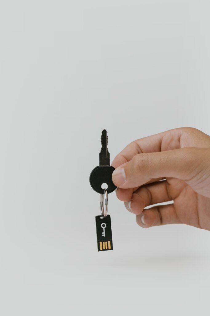 a person holding a key with a SIM card attached to it, representing the importance of information security policy writing services
