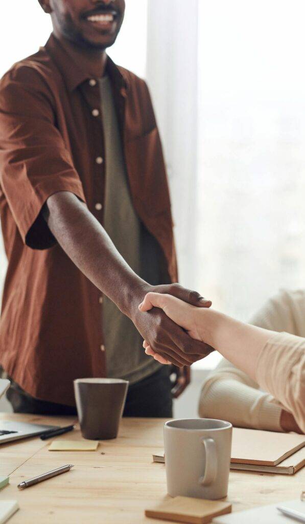 a Documentation Writer Shaking Hands with a Businessperson, Representing Beneficial Collaboration