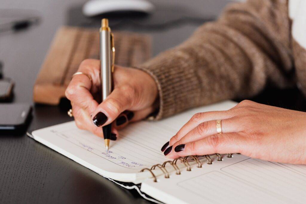a Person Writing in a Notebook, Representing the Importance of Proposal Writing for a Business