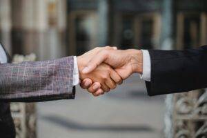a close-up image of two people shaking hands after completing a successful technical requirements document
