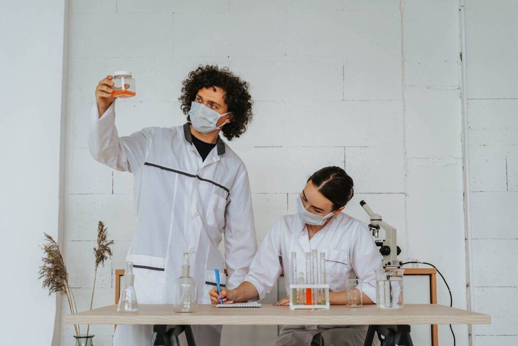 Two Scientists Examining Equipment and Liquids, Representing the Importance of Scientific Writing for Safety and Clarity