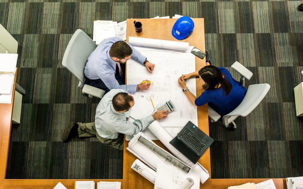 A view from above of a group of people working on a project at a conference table