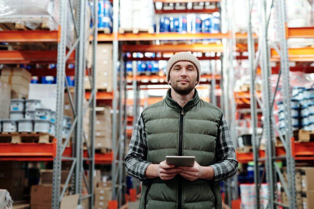a person standing in a warehouse, representing the importance of Employee Benefits Guide Writing Services
