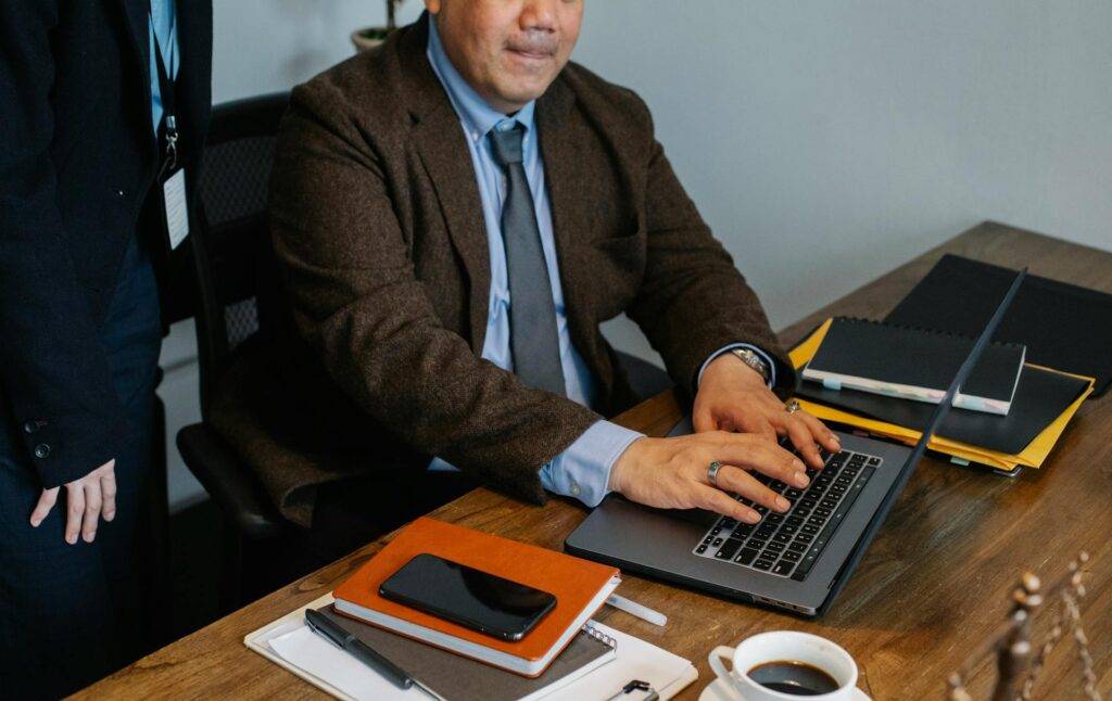 a Businessman at a Desk, Searching for the Answer to "What is a Documentation Writer" on his Laptop