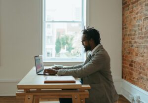 A man at a desk working a hybrid virtual job.