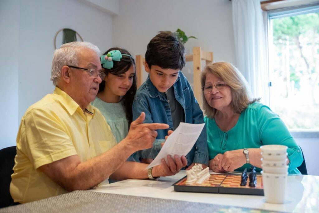 a Family reading an Instruction Manual while Huddled Around a Dining Table